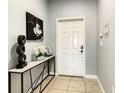 Bright entryway featuring a white door, neutral walls, and stylish decor on a sleek console table at 8845 Candy Palm Rd, Kissimmee, FL 34747