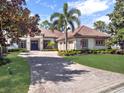 Beautiful single-story home with a tile roof, manicured lawn, and brick-paved driveway at 9372 Thurloe Pl, Orlando, FL 32827