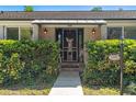 Inviting front entrance with decorative door, lantern lights, address plaque, and manicured hedges enhancing curb appeal at 1285 Seminole Ave, Longwood, FL 32750