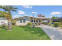 Well-maintained home featuring mature landscaping, a covered carport, and a welcoming facade at 1408 Schult Ct, Tavares, FL 32778