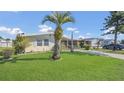 Exterior view of a charming single-story home with a manicured lawn and mature trees at 1408 Schult Ct, Tavares, FL 32778