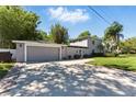 View of a two-car garage and driveway, complimented by a landscaped yard at 1519 N Westmoreland Dr, Orlando, FL 32804