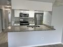 Bright kitchen features granite countertops, stainless steel appliances, and breakfast bar at 2020 Royal Bay Blvd # 92, Kissimmee, FL 34746