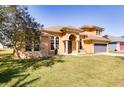 Tan two-story home with arched windows, manicured lawn, and a two-car garage at 2238 Amberly Ave, Orlando, FL 32833