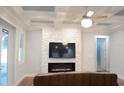 Living room featuring modern fireplace, coffered ceiling, and a contemporary ceiling fan at 402 S Hudson St, Orlando, FL 32835