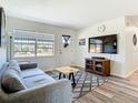 Comfortable living room with a gray sofa, wood-look floors, and a large window for natural light at 5322 Winter Run Dr, Orlando, FL 32839