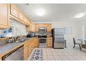 Functional kitchen features stainless steel appliances, light wood cabinets, and adjacent dining area at 651 Robinhood Dr, Maitland, FL 32751