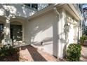 Close-up of exterior walls, front door and walkway featuring white trim and brick flooring at 6847 Sperone St, Orlando, FL 32819
