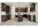 Spacious kitchen featuring dark wood cabinetry, stainless steel appliances, and a center island at 8433 Corkfield Ave, Orlando, FL 32832