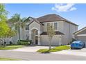 Beautiful home with a two-car garage, lovely landscaping, and a blue car in the driveway at 848 Jadestone Cir, Orlando, FL 32828