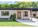 Inviting home exterior featuring a wooden front door, dark window trim, and fresh landscaping at 912 Citrus St, Orlando, FL 32805