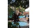 Inviting pool and bubbling hot tub surrounded by tropical plants and comfortable lounge seating at 12544 Floridays Resort Dr # 103B, Orlando, FL 32821