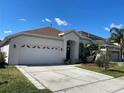 Lovely one-story home featuring a two-car garage, expansive driveway and manicured lawn with mature landscaping at 1352 Royal Saint George Dr, Orlando, FL 32828