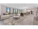Bright, open-concept living room with neutral tones, tile flooring and dining area at 1359 Wood Line Dr, Deland, FL 32720