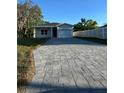 A cozy one-story house showcasing a long, gray stone driveway and light-colored fencing at 137 W G H Washington St, Apopka, FL 32703
