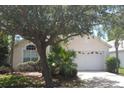 Single-story home featuring a two-car garage, neutral color palette, and well-maintained landscaping at 14136 Entrada Dr, Orlando, FL 32837