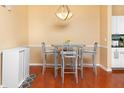 Bright dining area featuring wood floors, modern lighting, and a glass-topped table at 14316 Fredricksburg Dr # 507, Orlando, FL 32837
