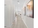 Bright hallway with neutral tile flooring leading to various rooms of the home at 1551 Flange Dr, Davenport, FL 33896
