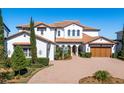 Beautiful Mediterranean-style home showcasing a brick driveway and meticulous landscaping at 15681 Panther Lake Dr, Winter Garden, FL 34787