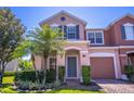 Close up of a charming two-story townhome with a colorful facade, lush landscaping, and front yard at 16241 Old Ash Loop, Orlando, FL 32828