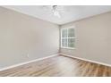 Bright bedroom with wood-look floors, a ceiling fan, and natural light streaming through the window at 2007 Royal Bay Blvd # 144, Kissimmee, FL 34746