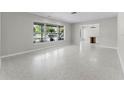 Bright, spacious living room with terrazzo flooring and large windows offering serene outdoor views at 2178 Whitehall Dr, Winter Park, FL 32792
