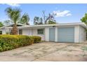 Charming single-story home with a light blue garage door, a palm tree, and tidy landscaping at 2319 Ashland Blvd, Orlando, FL 32808