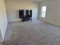 Spacious living room with carpeted floors, neutral walls, and a window for natural light at 268 Fiddlewood Ct, Davenport, FL 33837