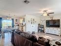 Open-concept living room featuring luxury vinyl flooring, a ceiling fan, and an adjacent dining area with access to the backyard at 278 Silverstone Dr, Orange City, FL 32763