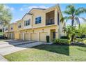 Inviting two-story townhome with four garages, a private balcony, and tropical landscaping at 2898 Oakwater Dr # 2898, Kissimmee, FL 34747