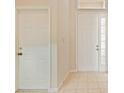 Bright entryway with neutral tiled floor and a front door with sidelight window at 2933 Star Grass Pt, Oviedo, FL 32766