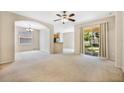 Spacious living room with neutral carpet, large sliding glass doors, and adjacent dining area at 2933 Star Grass Pt, Oviedo, FL 32766