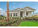 Inviting single-story home with gray exterior paint, landscaped garden beds, and a welcoming front porch at 33336 Seattle Slew Dr, Sorrento, FL 32776