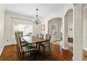 Elegant dining room with wood floors, modern chandelier, and large window for natural light at 3344 Quailwest Ct, Orlando, FL 32812