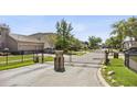 Community entrance gate with stone columns and wrought iron for privacy and security at 3344 Quailwest Ct, Orlando, FL 32812