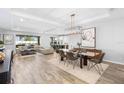 Open-concept living space featuring modern decor, wood-look tile flooring, and large windows with backyard views at 3375 Hanging Tide St, Winter Garden, FL 34787
