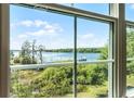 Scenic view of the lake through a large window, showcasing lush greenery and tranquil water at 3384 Corona Village Way # 202, Orlando, FL 32835