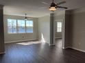 Spacious living room with dark wood floors, ceiling fans, neutral walls, and a scenic lake view at 3384 Corona Village Way # 202, Orlando, FL 32835