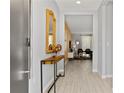 Inviting entryway with a console table, decorative mirror, and open view into the living area at 4445 Le Reve Ct, Kissimmee, FL 34746
