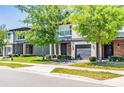 View of the front of modern townhomes, featuring brick driveways and well-maintained landscaping at 4445 Le Reve Ct, Kissimmee, FL 34746