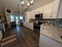 Modern kitchen with stainless appliances, stylish backsplash, ample cabinet space, and wood floors at 4798 Windwood Dr, Kissimmee, FL 34746