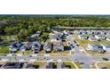 Aerial view of a modern neighborhood with tree-lined streets, a pond, and conveniently located near wooded area at 5251 Meredrew Ln, St Cloud, FL 34771