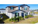 Two-story home featuring neutral siding, well-manicured front yard, and covered porch in a Gathering-friendly community at 5251 Meredrew Ln, St Cloud, FL 34771