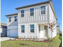 Two-story home with vertical siding, manicured lawn, and a welcoming front entrance at 5717 Haystack Dr, St Cloud, FL 34771