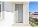 Inviting gray front door with sidelight panel, set in a bright white facade at 5717 Haystack Dr, St Cloud, FL 34771