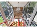 Unique glass-enclosed staircase with red railings and wooden steps, offering bright, natural light at 5824 N Dean Rd, Orlando, FL 32817
