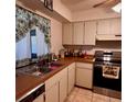 Functional kitchen with tile flooring, stainless steel oven, and white cabinetry at 604 Tradewinds Dr, Deltona, FL 32738