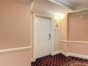 Hallway with a cream door and patterned walls, leading to a stylish and inviting space at 7593 Gathering Dr # 203, Reunion, FL 34747