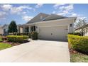 Single-story house featuring neutral siding, a two-car garage, and neatly trimmed hedges along the driveway at 7838 Penrose Pl, Wildwood, FL 34785