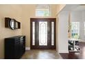 Grand foyer featuring a decorative front door with side panels and a high ceiling with natural light and tile flooring at 437 Wilmington Cir, Oviedo, FL 32765